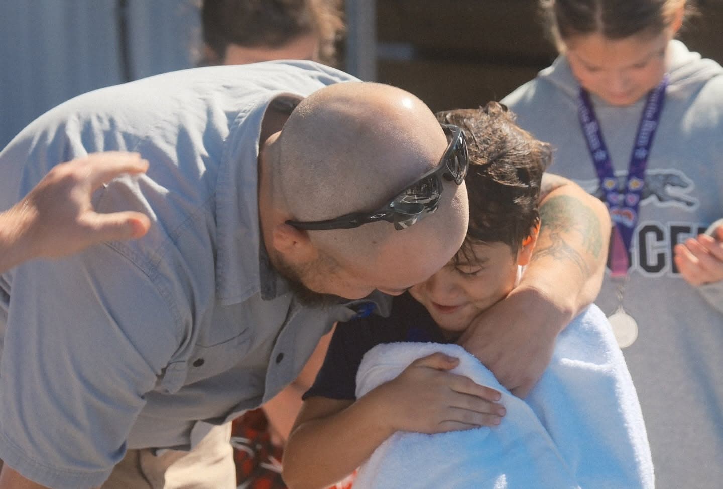 A leader embracing a child wrapped in a towel after a baptism at Discovery Church.